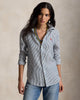 Woman wearing a striped shirt with a visible brand logo on a beige background